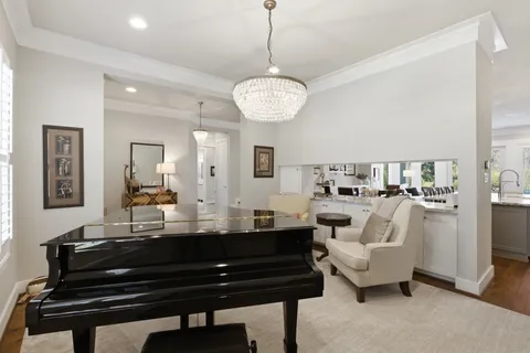 a dining room with wooden floor and chandelier