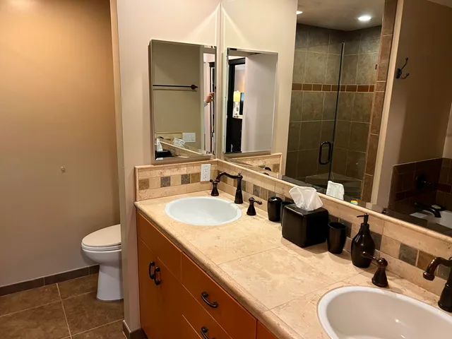 a bathroom with a double vanity sink toilet and mirror