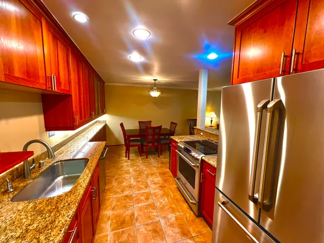 a kitchen with stainless steel appliances granite countertop a refrigerator and a sink