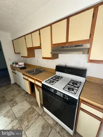 a stove top oven sitting inside of a kitchen