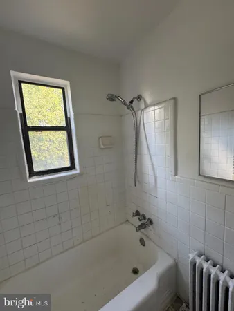 a bathroom with a bathtub and a window