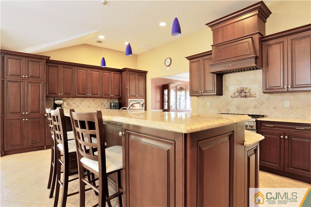 18 Homestead Road Freehold, NJ 07728 - Photo 16 of 32 a kitchen with granite countertop wooden cabinets and center island