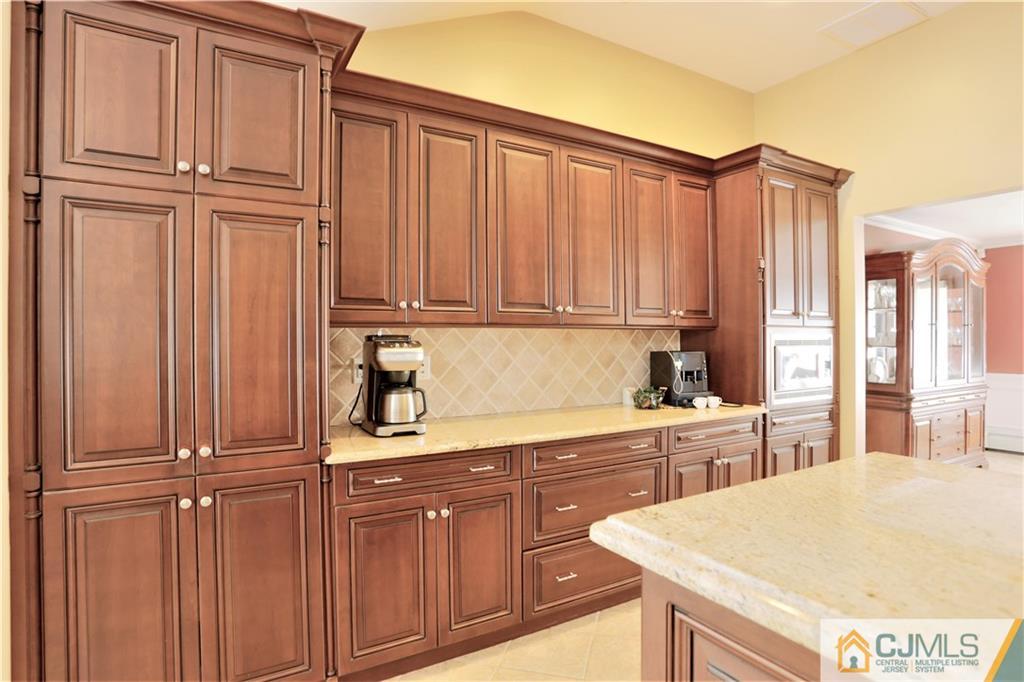 18 Homestead Road Freehold, NJ 07728 - Photo 17 of 32 a kitchen with kitchen island wooden cabinets and white appliances