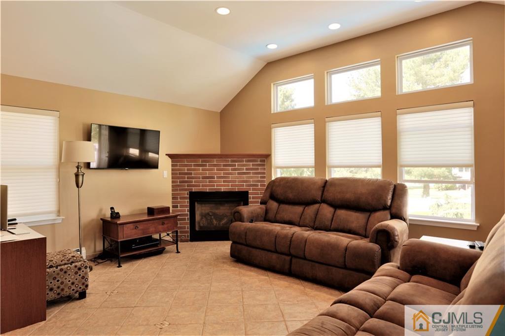 18 Homestead Road Freehold, NJ 07728 - Photo 19 of 32 a living room with furniture a flat screen tv and a fireplace