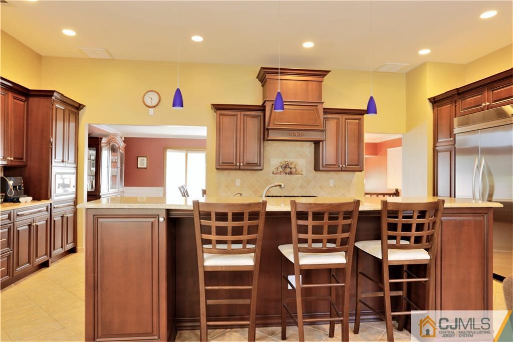 18 Homestead Road Freehold, NJ 07728 - Photo 20 of 32 a kitchen with stainless steel appliances kitchen island granite countertop a table and chairs