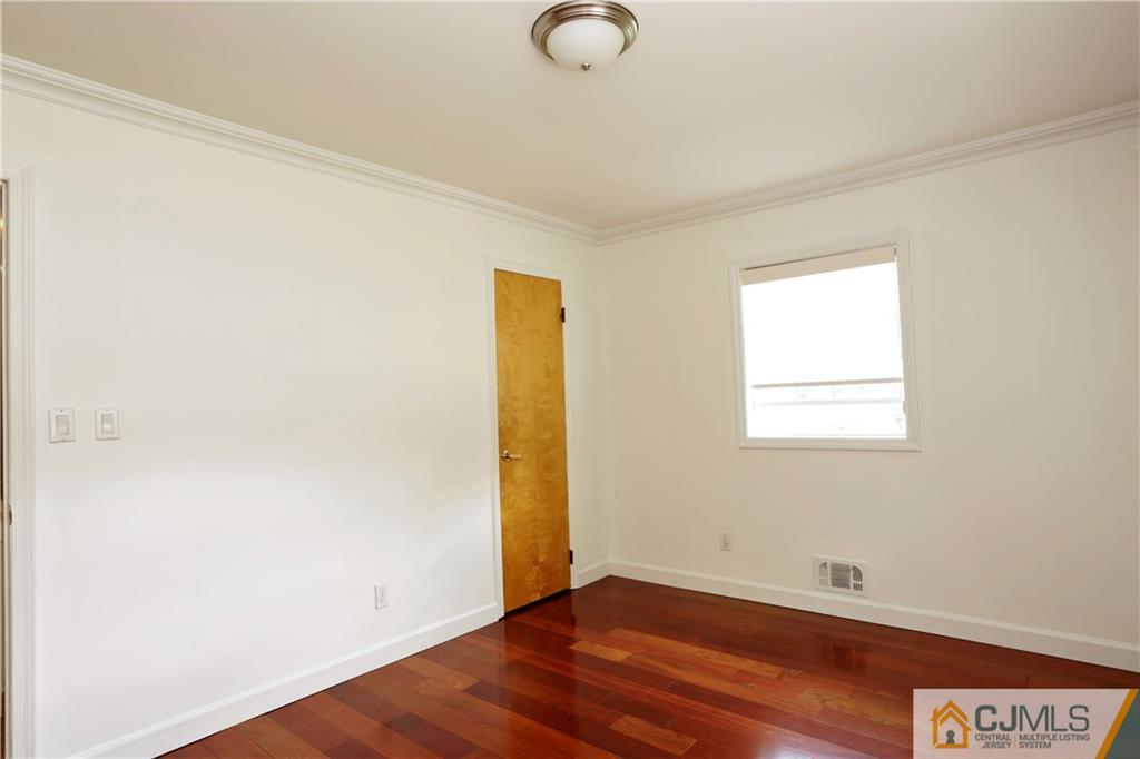 18 Homestead Road Freehold, NJ 07728 - Photo 25 of 32 a view of an empty room with wooden floor and a window