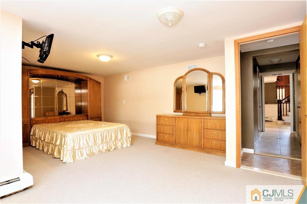 18 Homestead Road Freehold, NJ 07728 - Photo 8 of 32 a bedroom with a large bed and dresser with mirror