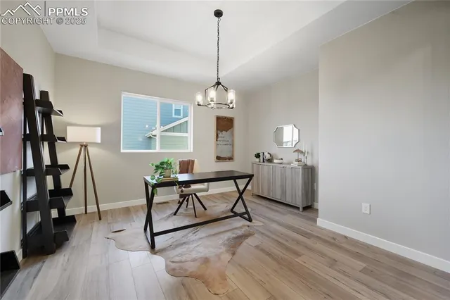 a dining room with wooden floor a chandelier a wooden table and chairs