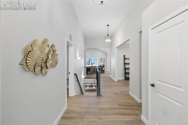 a view of a hallway view with wooden floor and a living room