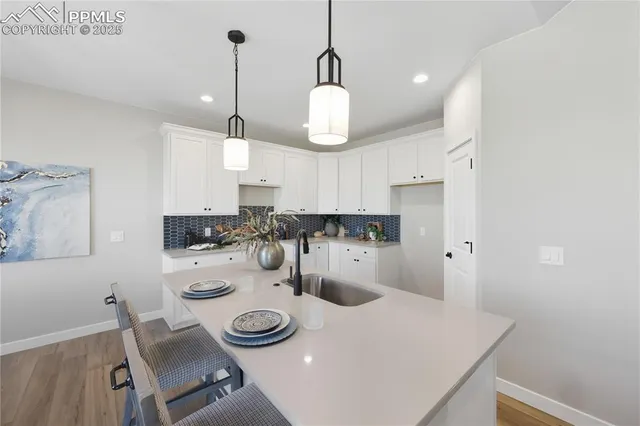 a kitchen with kitchen island white cabinets and refrigerator