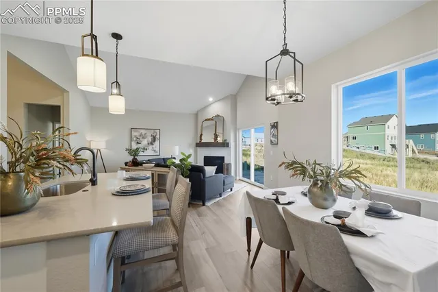 a view of a dining room with furniture a chandelier and wooden floor