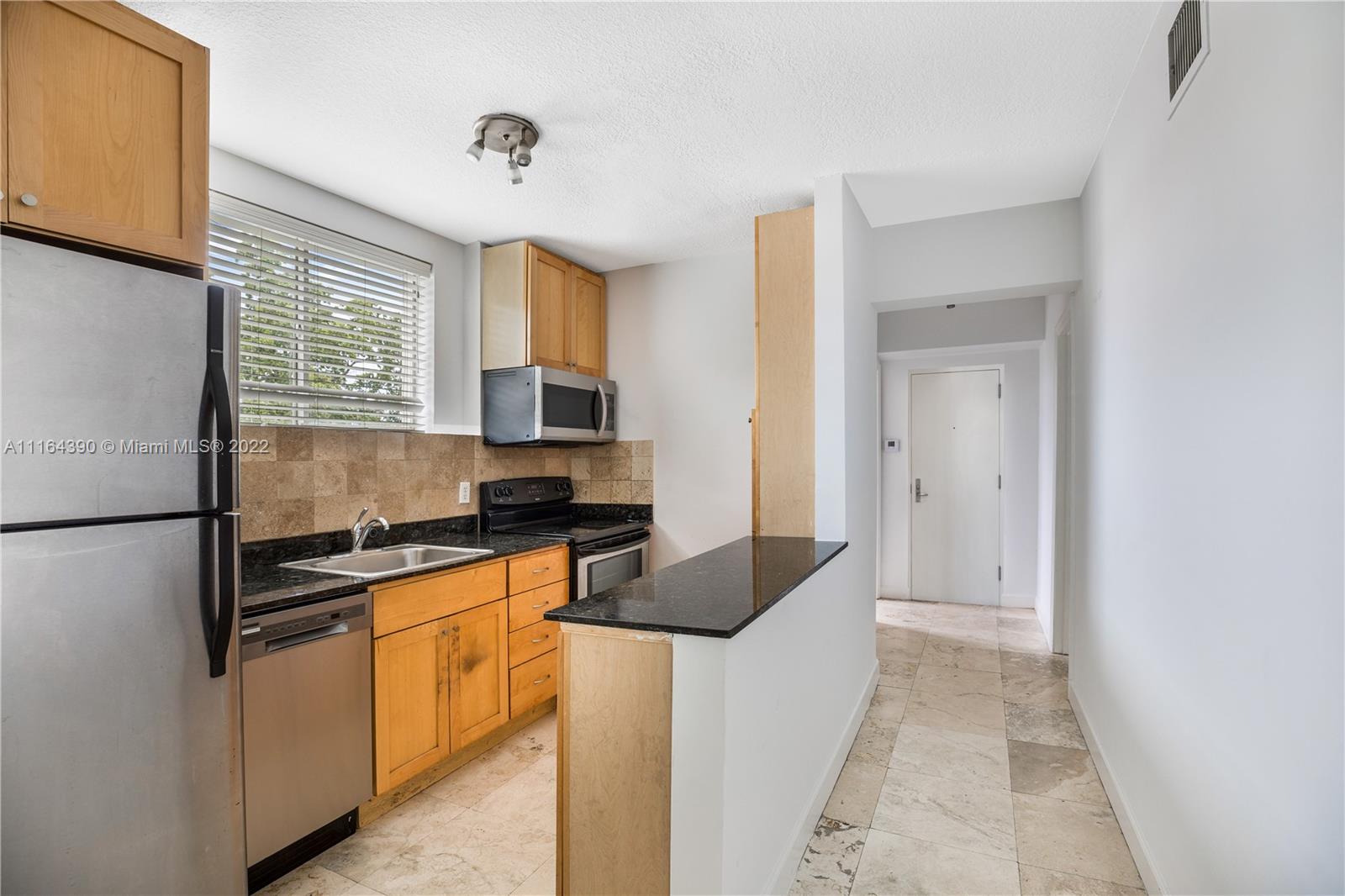 1025 Southwest 7th Avenue, Unit 9 Miami, FL 33129 - Photo 1 of 9 a kitchen with stainless steel appliances granite countertop a stove a sink and a refrigerator