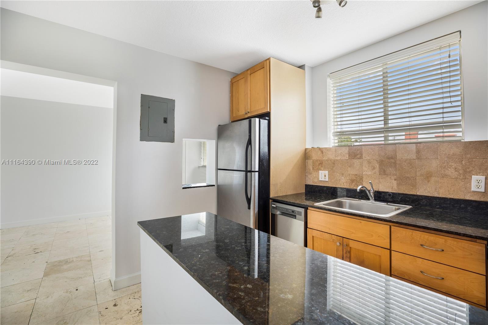 1025 Southwest 7th Avenue, Unit 9 Miami, FL 33129 - Photo 2 of 9 a kitchen with granite countertop a refrigerator and a sink