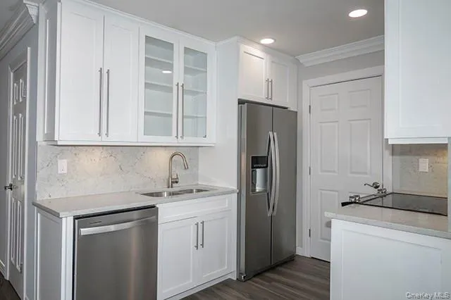 a kitchen with stainless steel appliances white cabinets and a refrigerator
