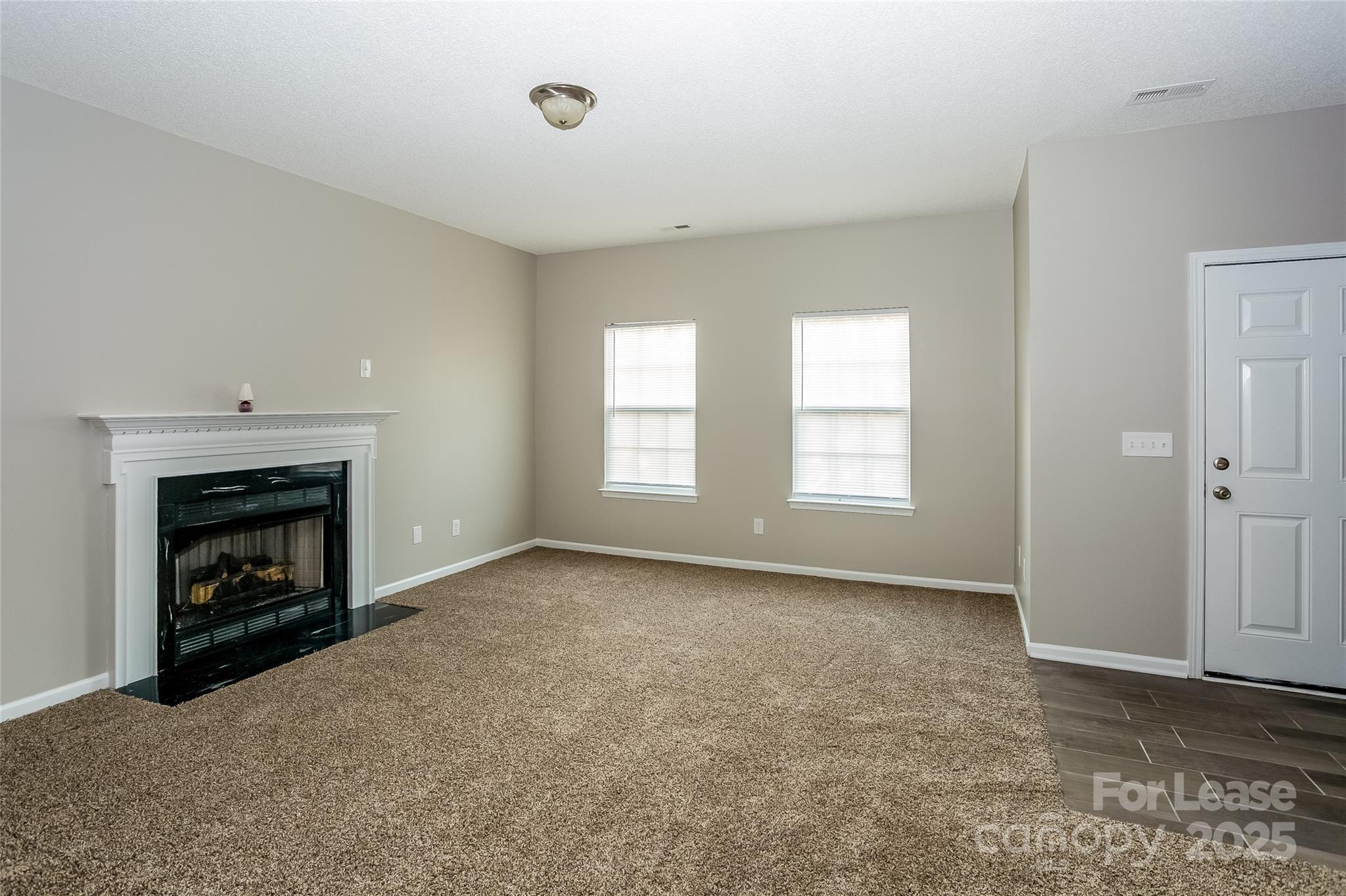 6131 Sid Crane Drive Charlotte, NC 28216 - Photo 5 of 17 an empty room with windows and fireplace