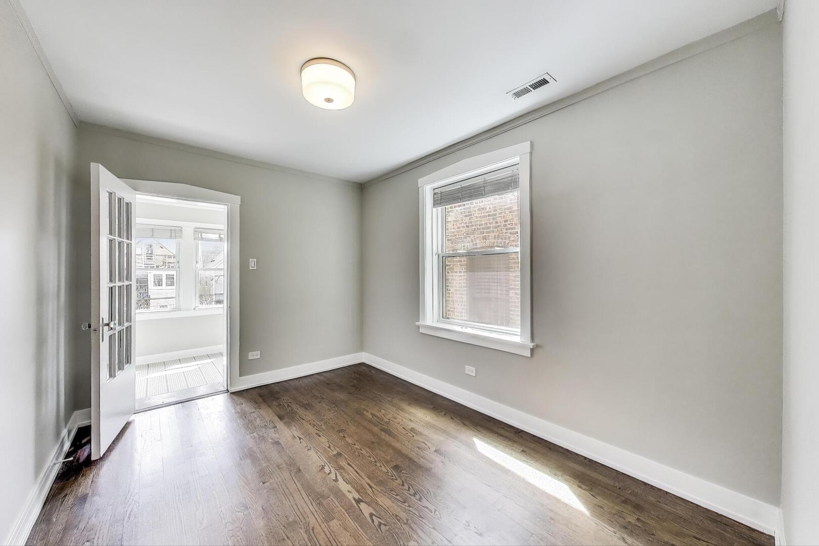 1451 West Warner Avenue, Unit 2 Chicago, IL 60613 - Photo 16 of 23 an empty room with wooden floor and windows