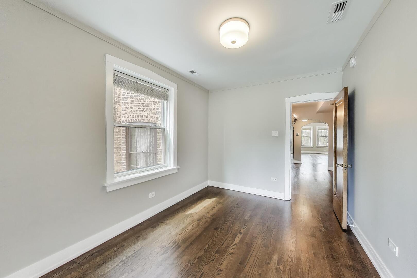 1451 West Warner Avenue, Unit 2 Chicago, IL 60613 - Photo 17 of 23 an empty room with wooden floor and windows