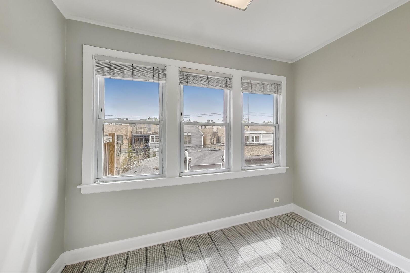 1451 West Warner Avenue, Unit 2 Chicago, IL 60613 - Photo 18 of 23 a view of an empty room with wooden floor and a window