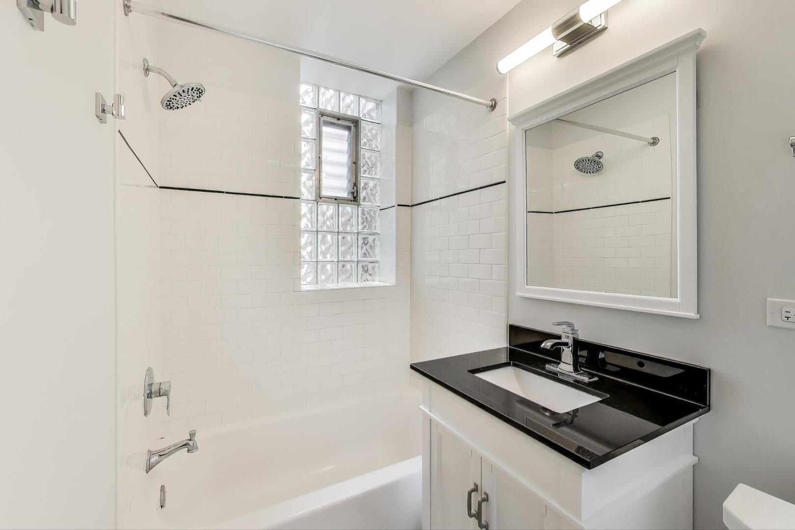 1451 West Warner Avenue, Unit 2 Chicago, IL 60613 - Photo 20 of 23 a bathroom with a sink and a mirror