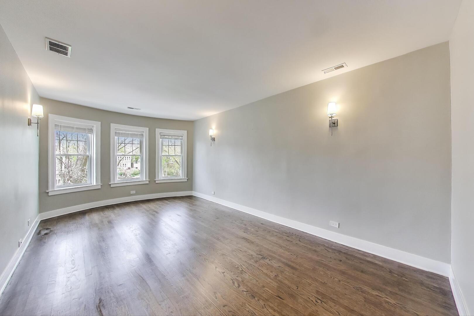 1451 West Warner Avenue, Unit 2 Chicago, IL 60613 - Photo 3 of 23 an empty room with wooden floor and windows