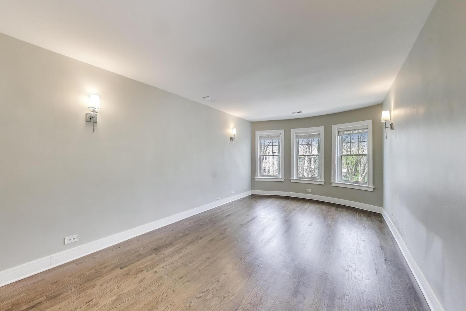 1451 West Warner Avenue, Unit 2 Chicago, IL 60613 - Photo 4 of 23 a view of an empty room with wooden floor and window