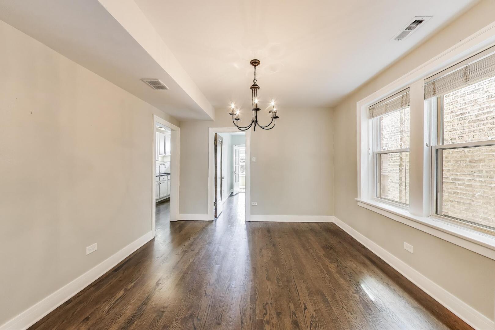 1451 West Warner Avenue, Unit 2 Chicago, IL 60613 - Photo 8 of 23 a view of a room with wooden floor chandelier and windows