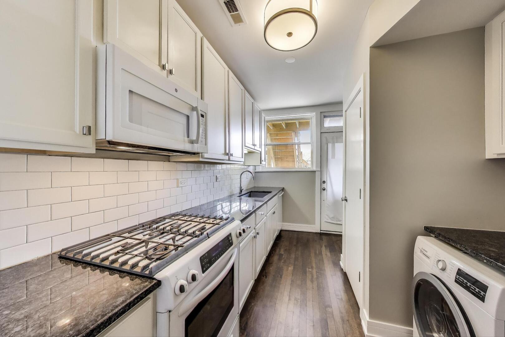 1451 West Warner Avenue, Unit 2 Chicago, IL 60613 - Photo 9 of 23 a kitchen with wooden floor and a stove top oven