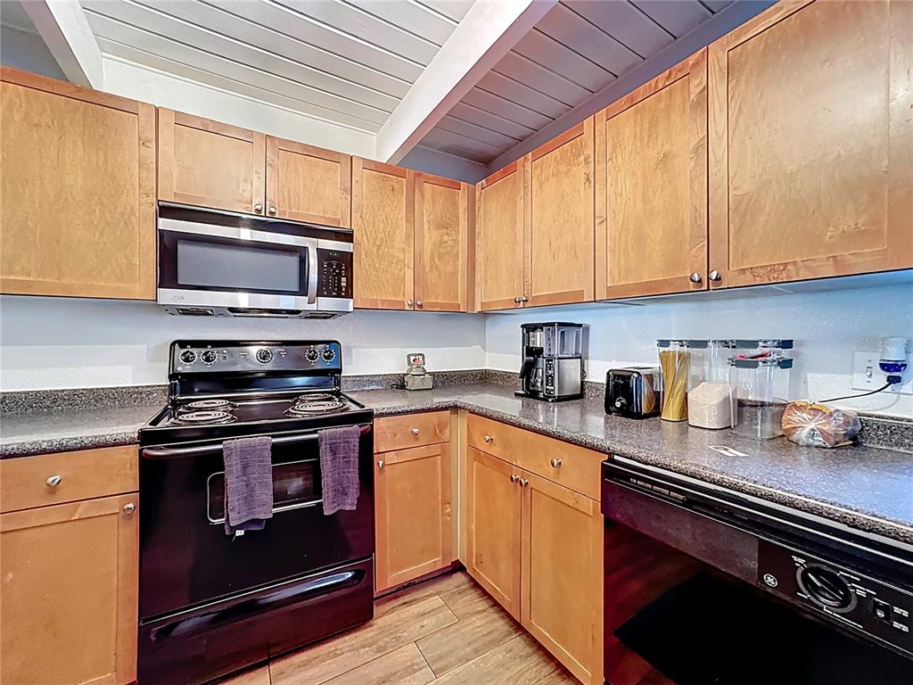 772 East Michigan Street, Unit 70 Orlando, FL 32806 - Photo 12 of 54 a kitchen with stainless steel appliances granite countertop a stove a sink dishwasher and a microwave