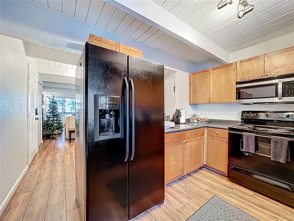772 East Michigan Street, Unit 70 Orlando, FL 32806 - Photo 16 of 54 a kitchen with stainless steel appliances granite countertop a refrigerator a stove and a sink with cabinets