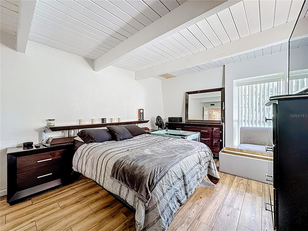 772 East Michigan Street, Unit 70 Orlando, FL 32806 - Photo 28 of 54 a bedroom with bed and wooden floor
