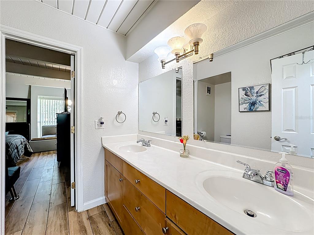772 East Michigan Street, Unit 70 Orlando, FL 32806 - Photo 31 of 54 a spacious bathroom with a granite countertop sink a mirror and shower