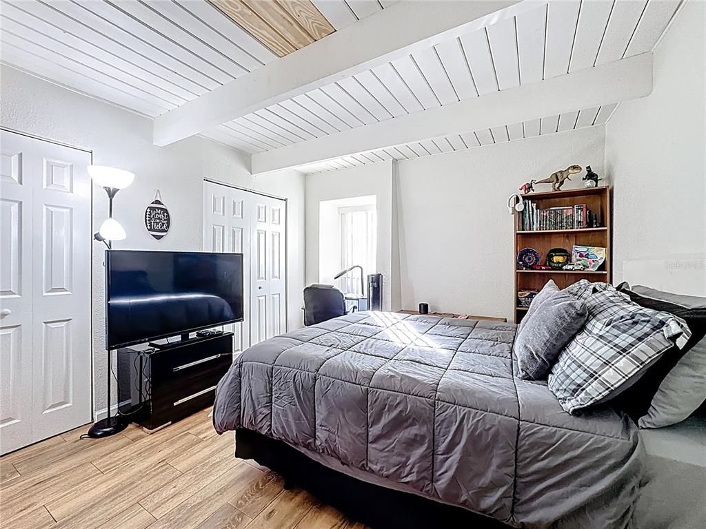 772 East Michigan Street, Unit 70 Orlando, FL 32806 - Photo 34 of 54 a bedroom with a bed and wooden floor