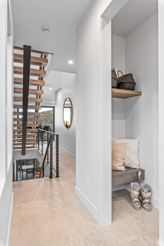 1258 Rothwell Road Park City, UT 84060 - Photo 25 of 48 Hallway featuring large format tile flooring, a built-in bench with a floating shelf, and a modern open-tread staircase with metal railings