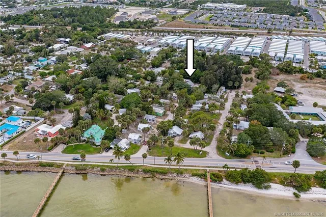 an aerial view of residential houses with outdoor space and trees