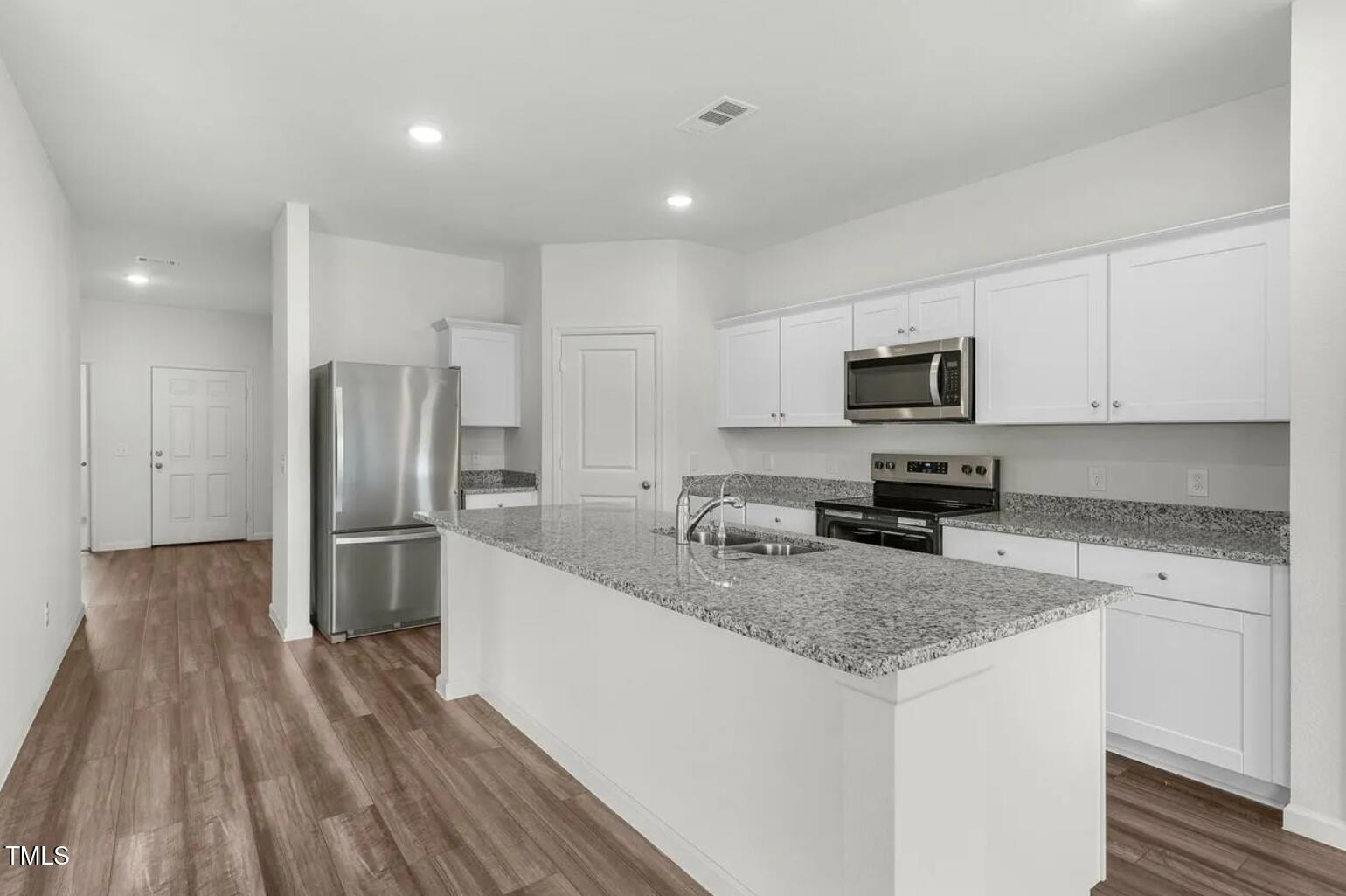 170 Bedstone Way Clayton, NC 27520 - Photo 4 of 22 a kitchen with a refrigerator a stove top oven a sink and dishwasher with wooden floor