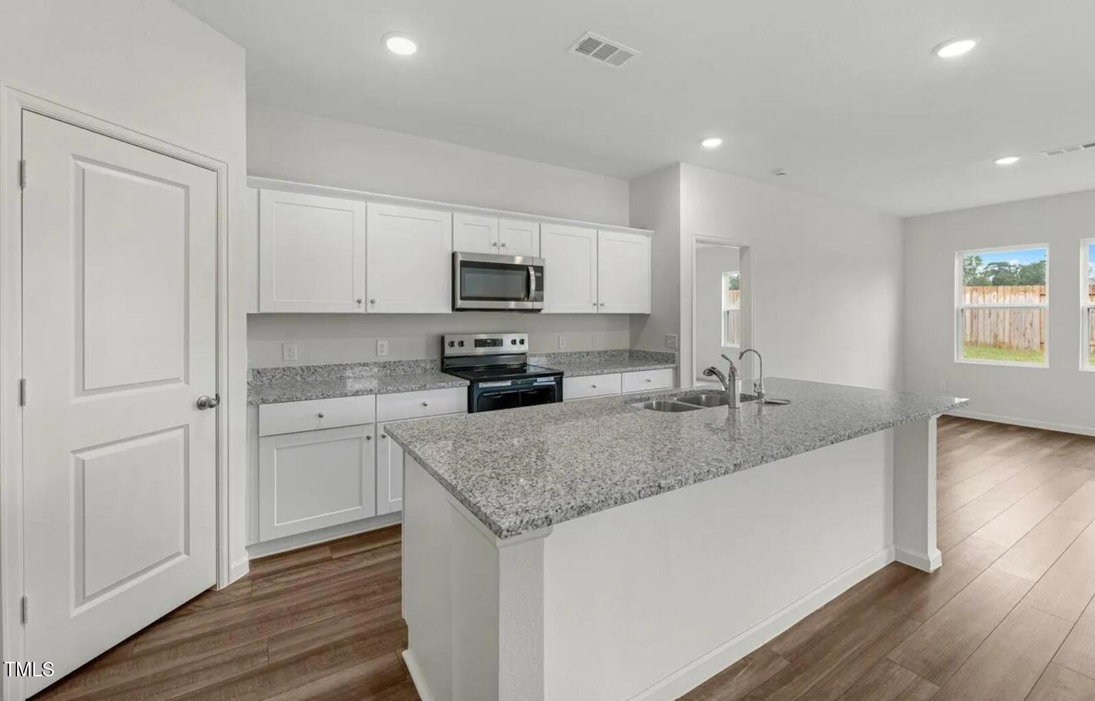 170 Bedstone Way Clayton, NC 27520 - Photo 6 of 22 a kitchen with stainless steel appliances granite countertop a sink a microwave counter space and cabinets