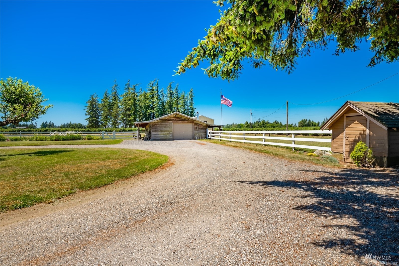 356 East Pole Road Lynden, WA 98264 - Photo 26 of 40 a view of a swimming pool with a lawn chairs under an umbrella
