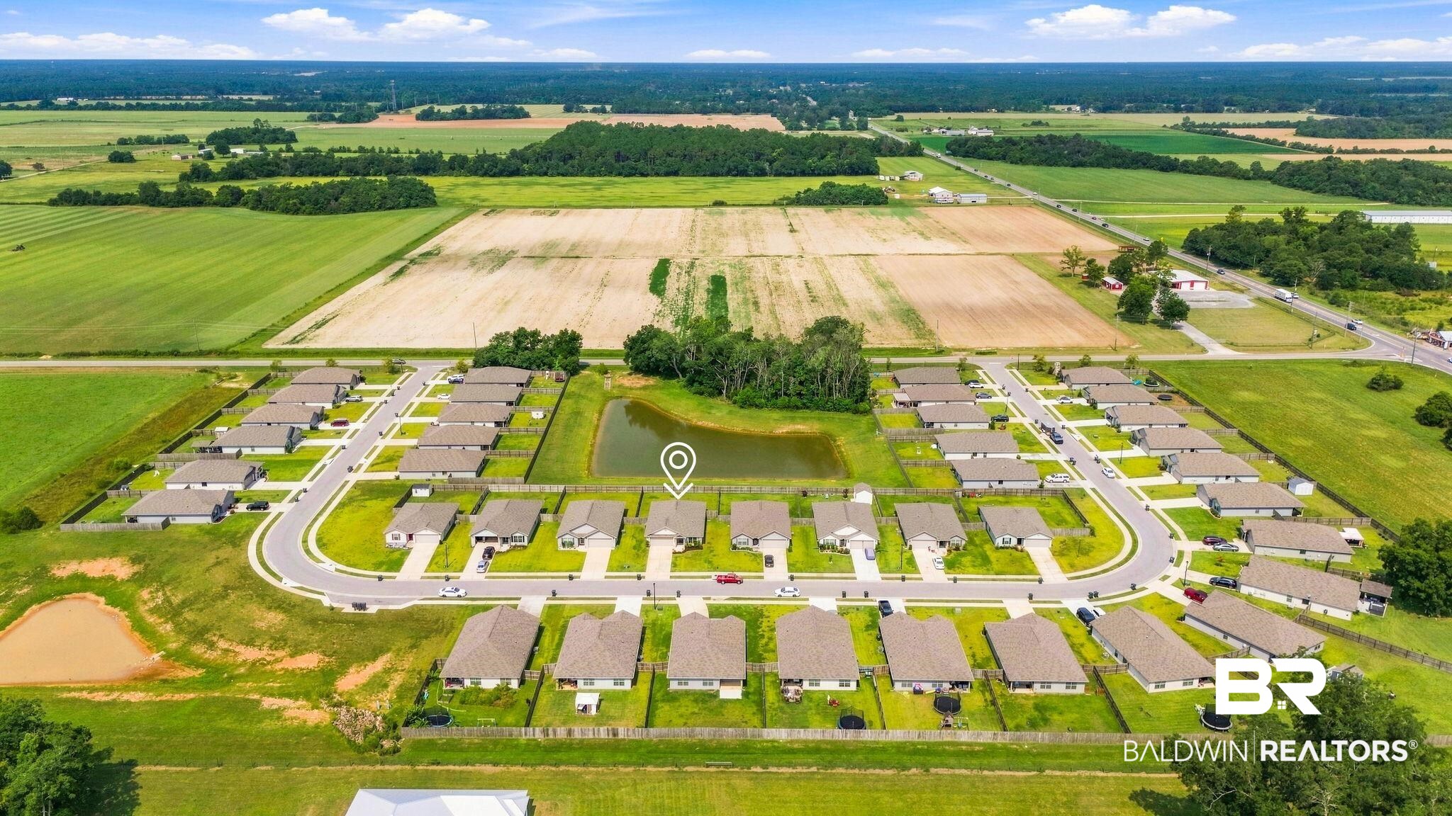 32155 Terranova Loop Lillian, AL 36549 - Photo 35 of 37 Aerial perspective showcasing a residential development with individual houses, paved roads, and a central pond