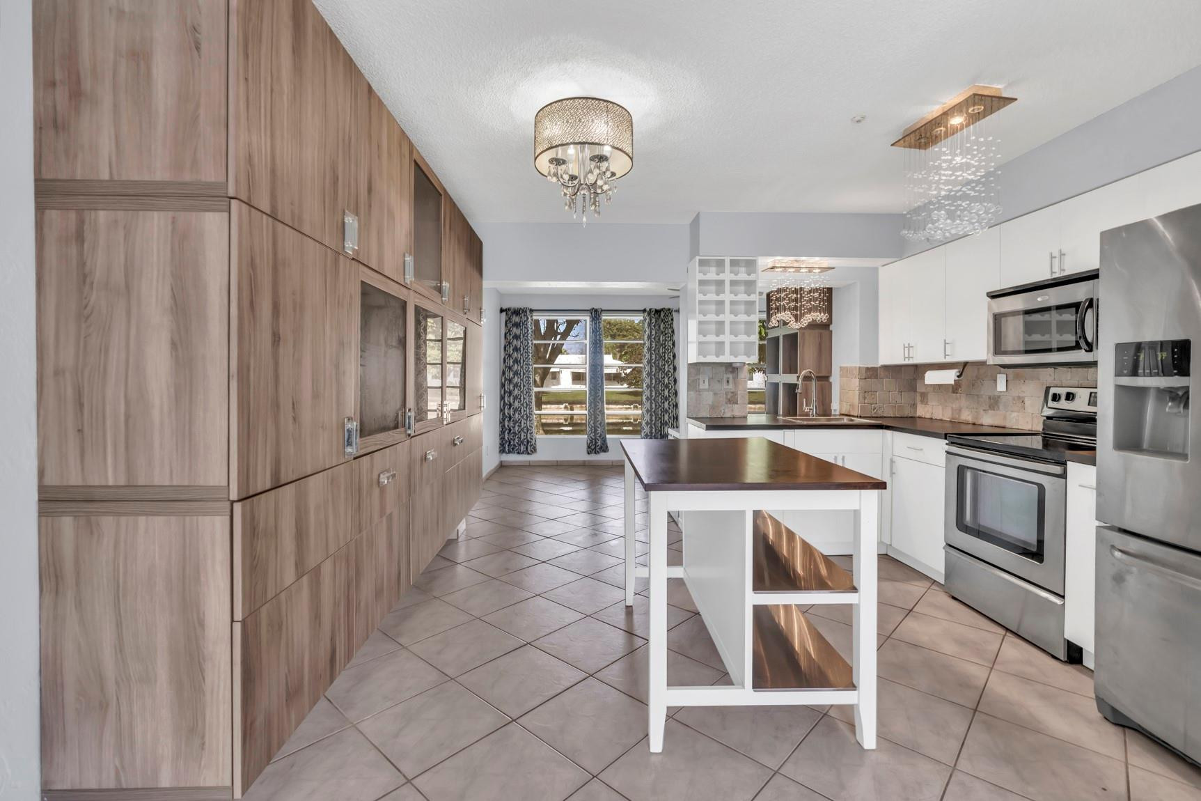 7115 Northwest 73rd Street Tamarac, FL 33321 - Photo 12 of 46 a kitchen with stainless steel appliances granite countertop a refrigerator and a stove top oven