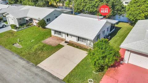 an aerial view of a house with a yard and a large tree