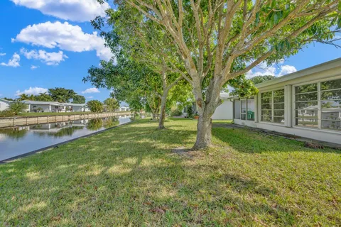 a view of a house with backyard and tree