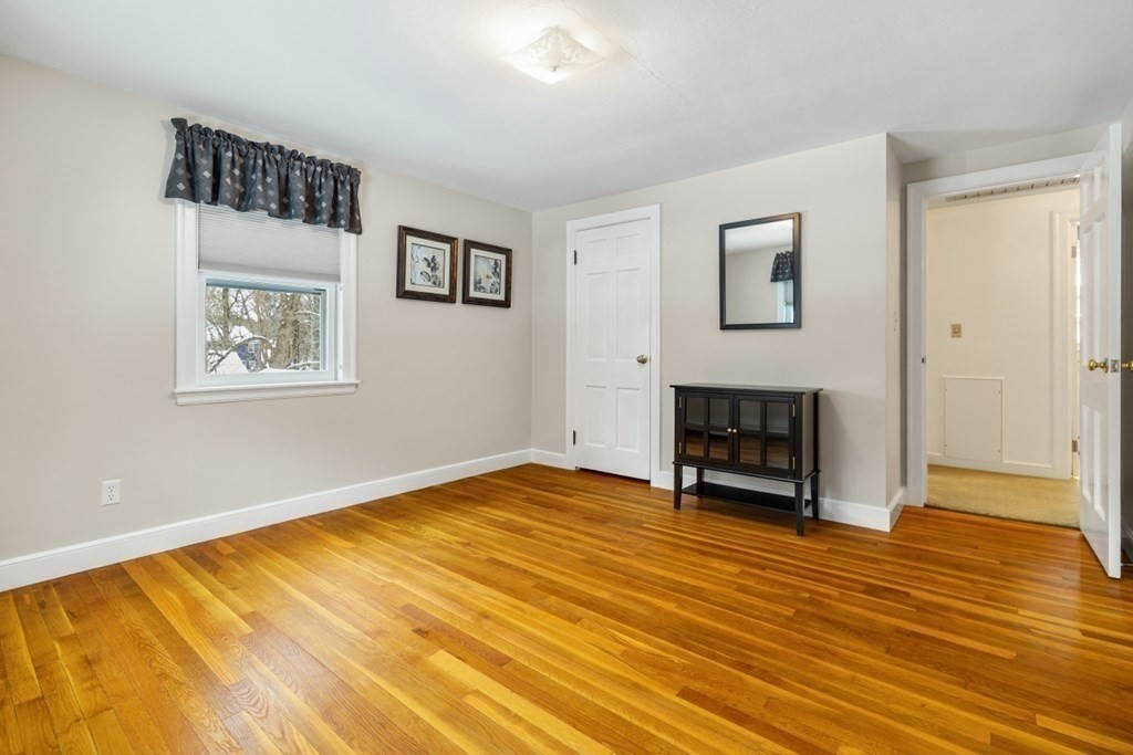 6 Sherman's Bridge Road Wayland, MA 01778 - Photo 27 of 42 a view of an empty room with wooden floor and a fireplace