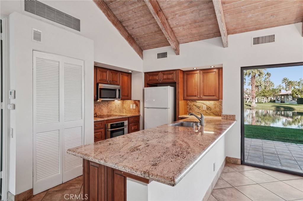 380 Wimbledon Drive Rancho Mirage, CA 92270 - Photo 13 of 41 a kitchen with stainless steel appliances granite countertop a sink stove and refrigerator