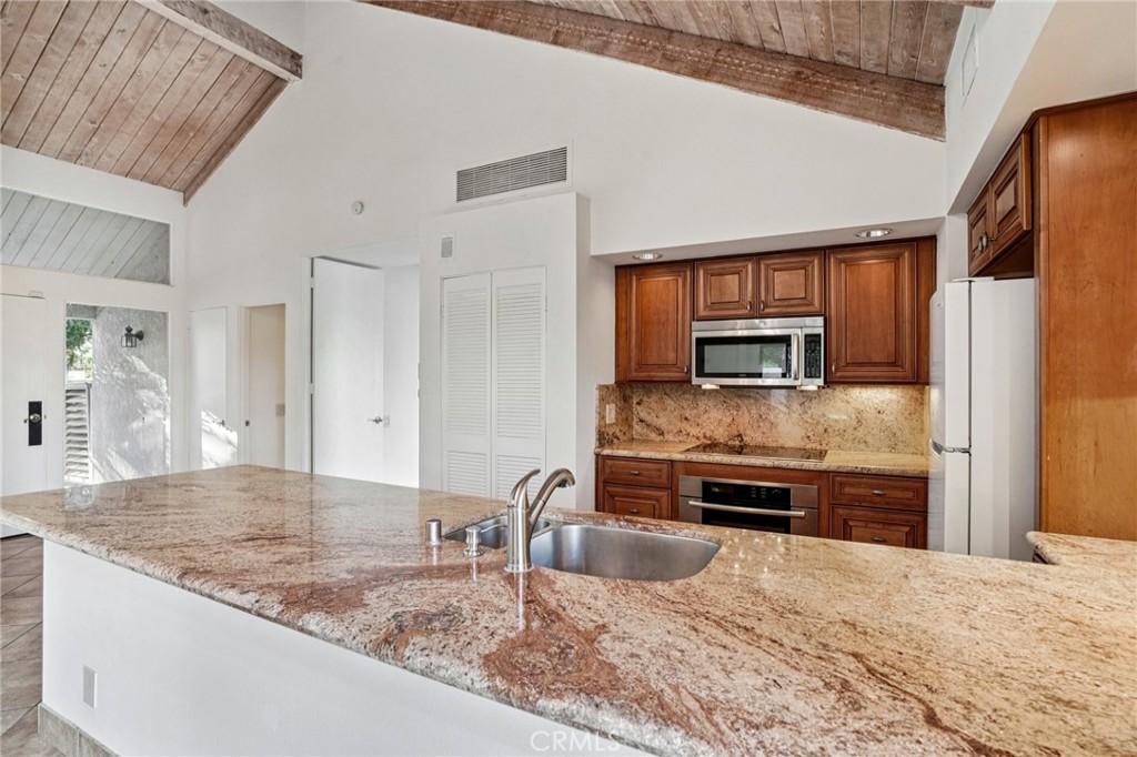 380 Wimbledon Drive Rancho Mirage, CA 92270 - Photo 14 of 41 a large kitchen with kitchen island granite countertop a large counter top stainless steel appliances and cabinets