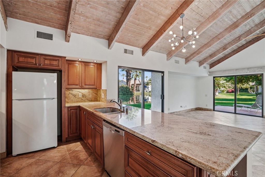 380 Wimbledon Drive Rancho Mirage, CA 92270 - Photo 15 of 41 a kitchen with stainless steel appliances granite countertop a sink a refrigerator and a wooden floors