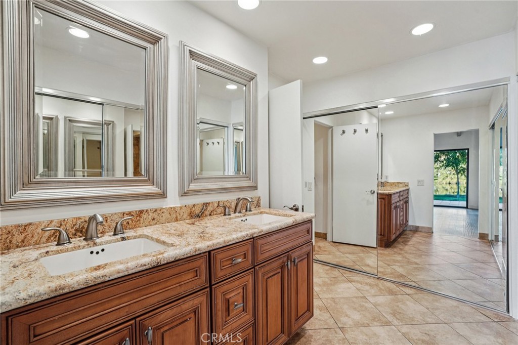 380 Wimbledon Drive Rancho Mirage, CA 92270 - Photo 23 of 41 a bathroom with a granite countertop double vanity sink a mirror and a shower