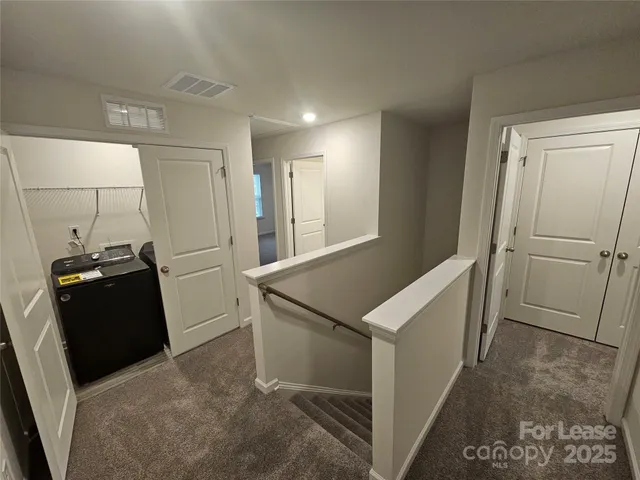 a view of a refrigerator in kitchen and an empty room