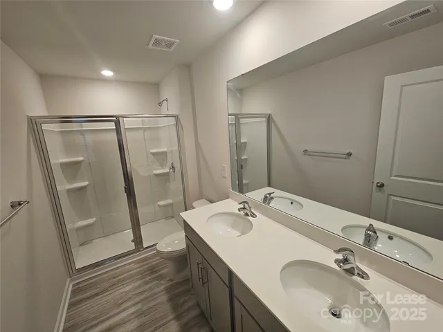 a bathroom with a sink a mirror a vanity and shower