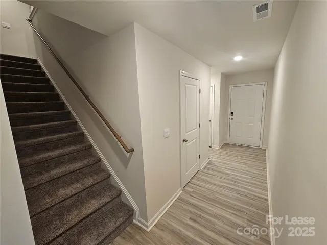 a view of a hallway with wooden floor and entryway