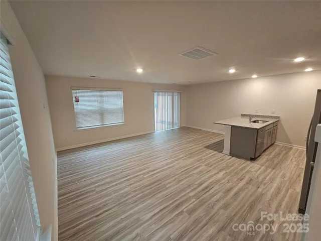an empty room with wooden floor and window